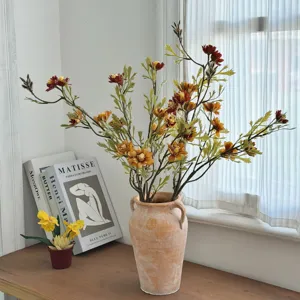 Detailed view of vintage autumnal artificial wild chrysanthemums in a rustic terracotta vase