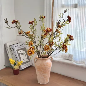 Detailed shot of autumn-themed artificial wild chrysanthemum bouquet in a rustic clay vase