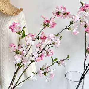 Detailopname van realistische roze en witte kunstkersenbloesemtakken voor interieur.