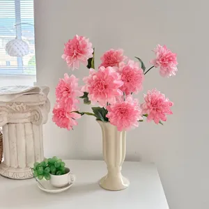 Detailed view of lifelike pink artificial dahlia flowers in a cream vintage ceramic vase