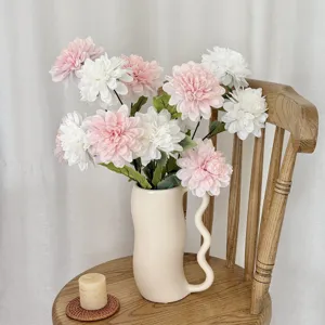 Detail view of realistic pink and white 3-head artificial dahlia flowers in a ceramic vase