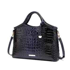 Primer plano de un bolso vintage azul marino con textura de cocodrilo y herrajes dorados.