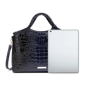 Bolso vintage azul marino con patrón de cocodrilo mostrado con tablet para tamaño