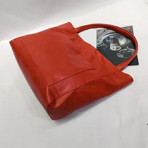 Vista detallada de un gran bolso tote rojo de cuero sintético suave con bolsillo
