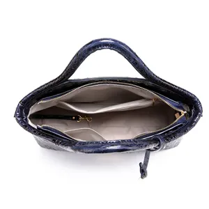 Vista interior detallada de bolso azul marino con grabado de cocodrilo y bolsos