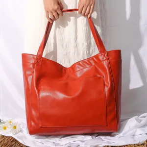 Bolso tote elegante de cuero encerado rojo con bolsillo frontal sujeto por mujer