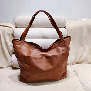 Bolso tote retro de cuero encerado marrón con gran capacidad y bolsillo frontal.