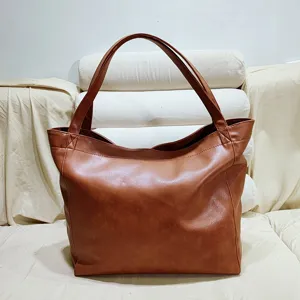 Detalle de primer plano del cuero encerado vintage marrón de este bolso tote grande