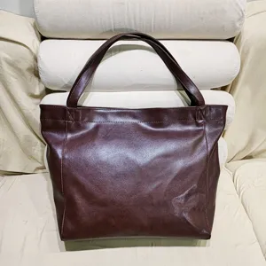 Detalle de un bolso tote vintage de cuero encerado marrón con una textura muy suave