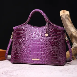 Vista detallada de un bolso de lujo morado con textura de cocodrilo en relieve