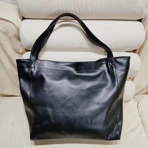 Primer plano de un bolso tote grande de cuero negro suave que muestra la textura