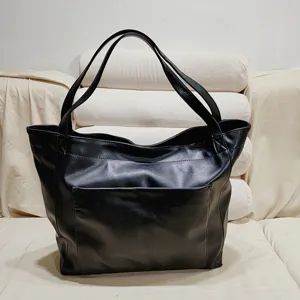 Detalle del bolso tote grande de cuero encerado vintage negro con bolsillo frontal