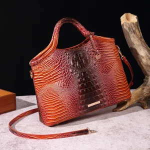 Primer plano detallado de la textura de cocodrilo 3D en el bolso retro de color marrón.