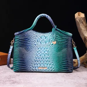 Primer plano de bolso degradado verde azulado con textura de cocodrilo