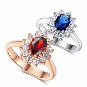 Detail view of oval halo rings with red and blue gemstones in rose gold and silver