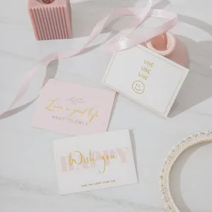 Primer plano de tarjetas de felicitación plegables con citas inspiradoras en pan de oro