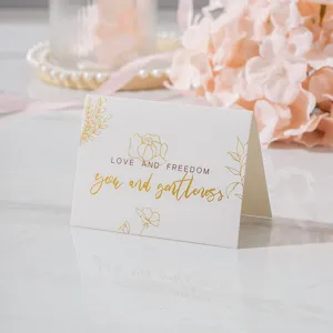 Vista detallada de una elegante tarjeta de felicitación blanca con diseños dorados