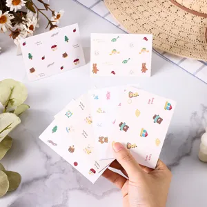 Hand holding a set of cute cartoon greeting cards featuring bear and rabbit patterns for gifts