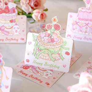 Close-up of 3D birthday cards with cute cake illustrations and Happy Birthday text