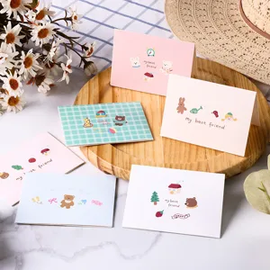 Assorted cute cartoon animal greeting cards with inscriptions on a wooden tray