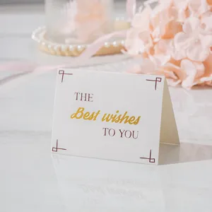 Elegante tarjeta de felicitación plegada con texto dorado 'Best wishes' en mármol.