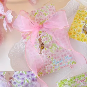 Close-up detail of romantic floral greeting card featuring an elegant pink organza ribbon bow