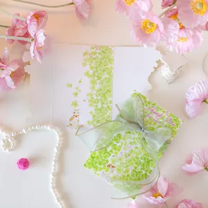 Detailed view of elegant green clover greeting card featuring a large translucent ribbon bow