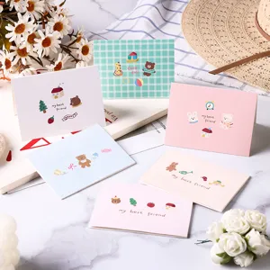 Selection of cute cartoon animal greeting cards with pastel designs and cozy props.