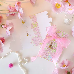 Detail of pink floral greeting card with elegant ribbon and thank you message.