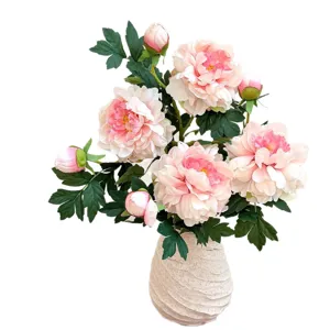 Lifelike pink artificial peony flowers in a stylish white ceramic vase for home decor