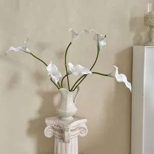 Elegantes calas artificiales blancas en un jarrón vintage con relieve para hogar.
