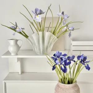 Elegant artificial purple and blue iris flowers in vases for home or wedding decor.