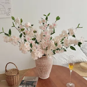 Elegant artificial cherry blossom branches in ceramic vase for modern home room decor