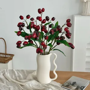 Artificial red berry plant branches in aesthetic wavy white ceramic vase decor