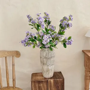 Elegant artificial lilac flowers in a textured vase for cozy home living room decor