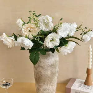 Detail of white artificial peony flowers in a textured vase for home table decor
