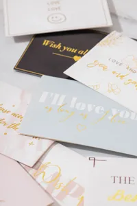 Vista detallada de elegantes tarjetas de felicitación con textos románticos dorados