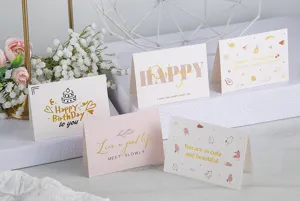 Tarjetas de felicitación plegadas con lámina de oro, dibujos lindos y mensajes