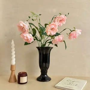 Elegant pink artificial peonies in a stylish black trumpet vase for home decor