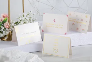 Detalle de cuatro elegantes tarjetas de felicitación con letras en pan de oro