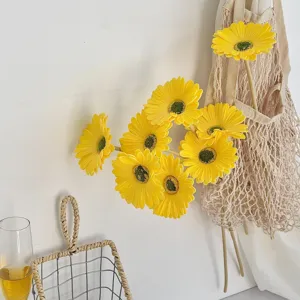 Vista detallada de flores de gerbera artificiales de PU amarillo vibrante para decorar el hogar.