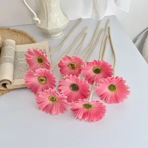 Vista detallada de flores de gerbera artificiales de PU rosa con textura de pétalos