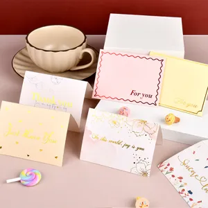 Collezione di eleganti biglietti d'auguri in oro con motivi floreali e d'amore.