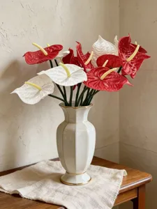 A detailed view showing red and white EVA artificial Anthurium flowers in an elegant vase