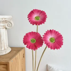 Vista detallada de tres margaritas gerberas de PU rosas con centros verdes