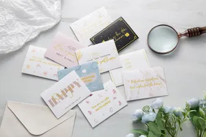 Vista detallada de varias tarjetas de felicitación creativas con lámina de oro e ilustraciones.