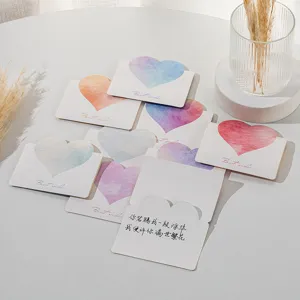 Close-up of minimalist heart-shaped greeting cards with watercolor designs and message