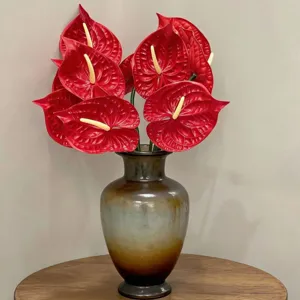 Large realistic red EVA anthurium artificial flowers displayed in a vintage vase