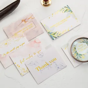 Primer plano de elegantes tarjetas de felicitación con diseños florales y de mármol