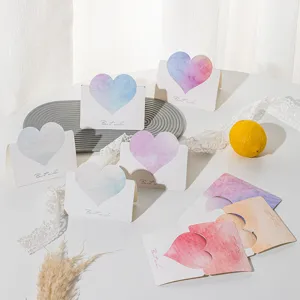 Detailed view of colorful heart-shaped greeting cards with Best Wishes text on a table
